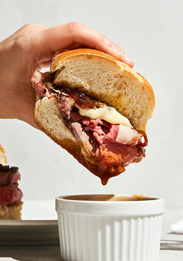 Image of Prime Rib French Dip with Honey Onions and Brandy Jus